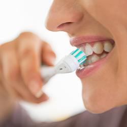 Profile view of woman brushing teeth