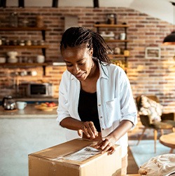 Woman in kitchen space opening box