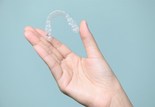 Closeup of patient holding clear aligner