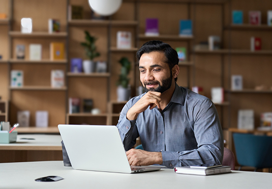 Man sitting at table using his laptop