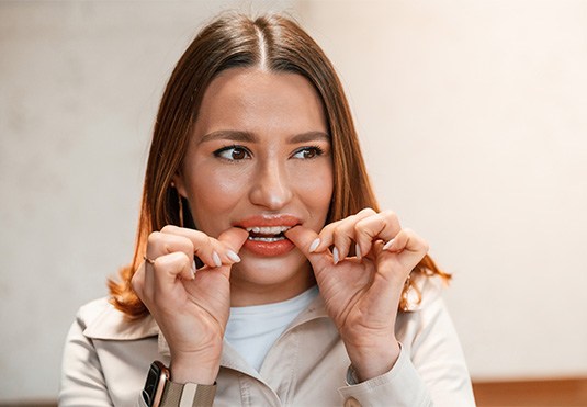 Patient putting on clear aligner in treatment room