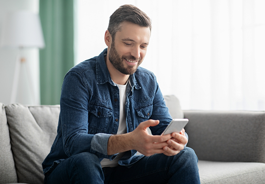 Man smiling while scrolling on his phone